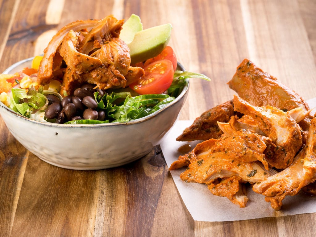 Delicious sauce-coated Slow Cooked Chicken Tinga from Dawn Farms served with a fresh avocado salad.