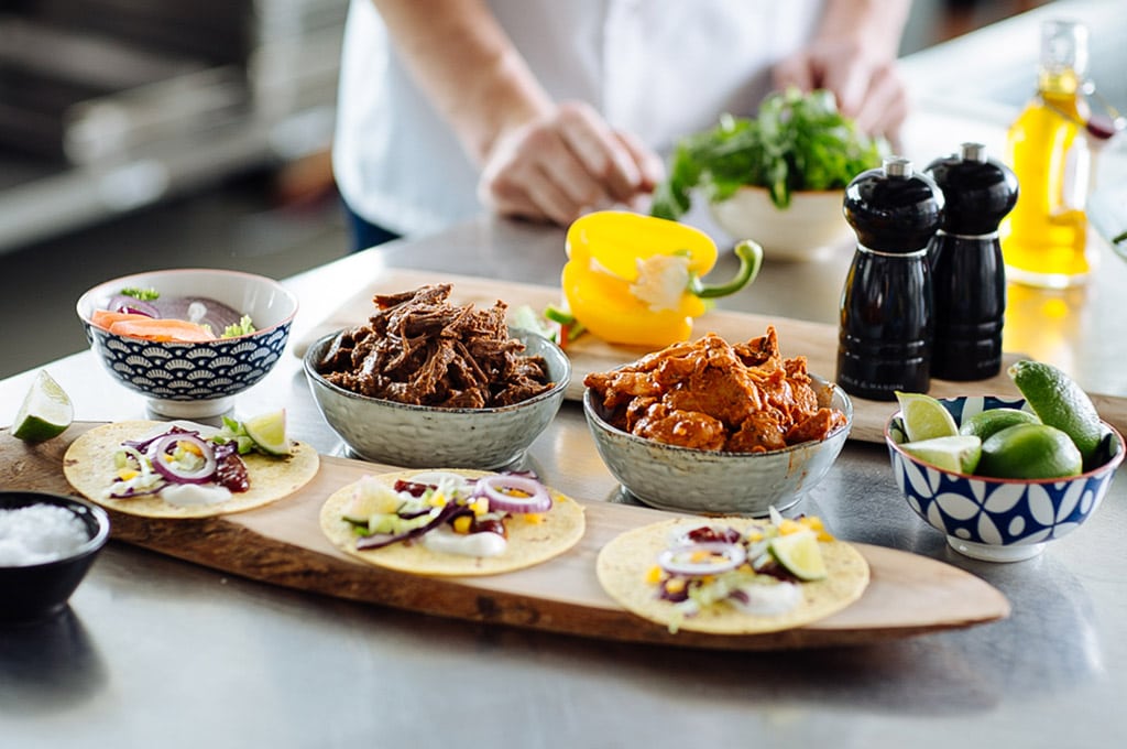 A wooden platter in the Dawn Farms test kitchen holds small flour tortillas with different flavour combinations, including Beef Barbacoa and Slow Cooked Chicken Tinga.
