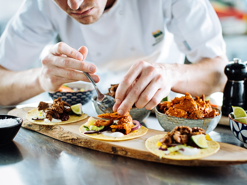 A chef in the Dawn Farms test kitchen puts to the finishing touches to an array of small flour tortillas with different flavour combinations, including Beef Barbacoa and Slow Cooked Chicken Tinga.