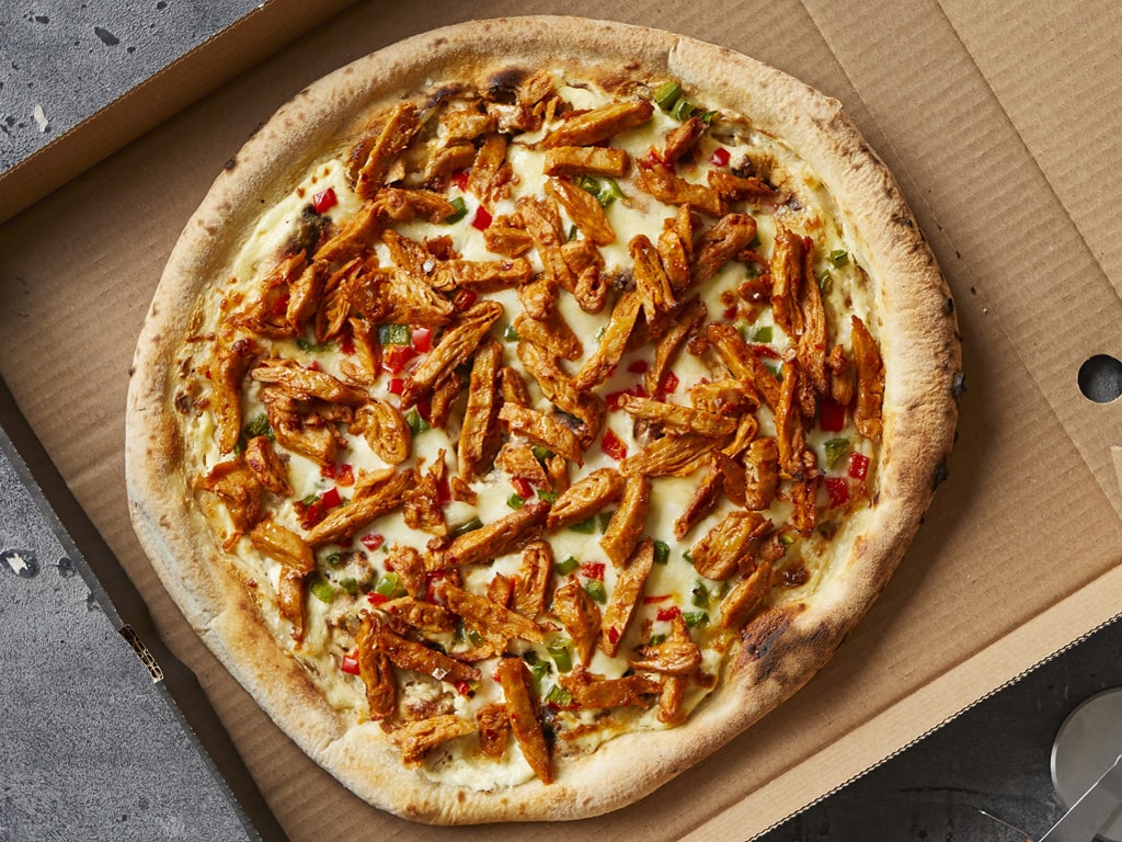 A cheese pizza loaded with vegetarian and meat-free Plant Deli Tikka strips.