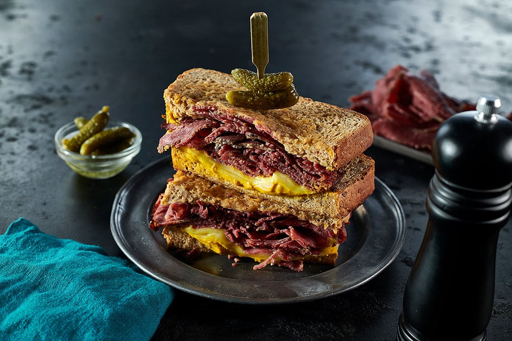 A double-stacked pastrami on rye sandwich, containing layers of Dawn Farms Batch 85 peppered pastrami.