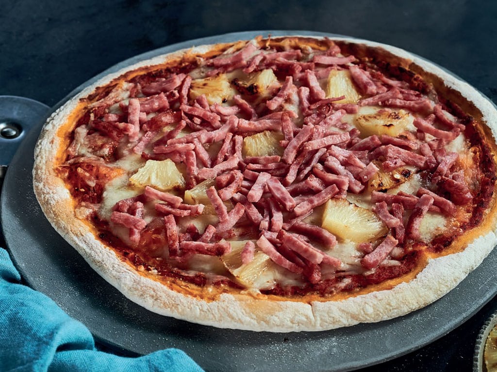 A hawaiian-style pizza with pineapple and Habibi halal turkey julienne toppings.